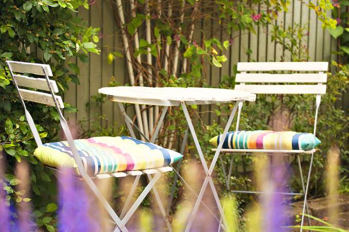 Bunte Sitzkissen auf zusammenklappbaren Gartenstühlen