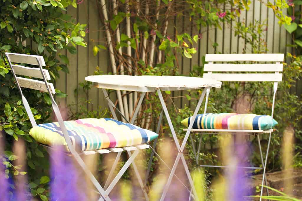 Gartenmöbel für kleine Gärten und Balkone Bunte Sitzkissen auf zusammenklappbaren Gartenstühlen